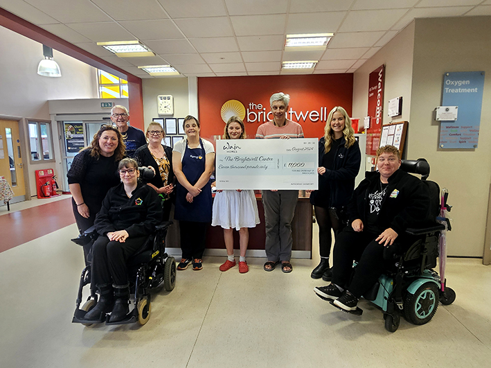 Doro Pasantes, CEO The Brightwell (far left) is joined by Brightwell members and volunteers to receive an £11,000 donation presented by Maisie Boyd from Wain Homes (pictured second from right)